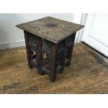 An Eastern hardwood square top table with folding pierced sides and relief carved top (losses) (h.