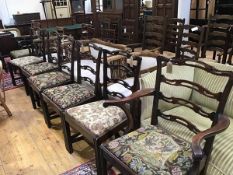 A set of ten plus two 19thc mahogany ladderback dining chairs with inset needlework seats, raised on