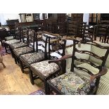 A set of ten plus two 19thc mahogany ladderback dining chairs with inset needlework seats, raised on