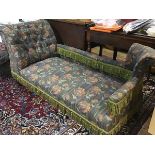 An Edwardian oak chaise longue with upholstered panel back and button scroll arm, in tapestry