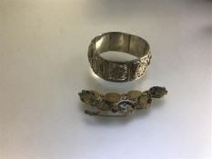 A Chinese white metal panelled openwork bracelet (d.6cm) (49.6g) and a Japanese oval gilded yellow