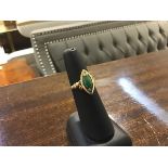 A 14ct gold ring set marquise shaped jadeite green panel mounted with leaf scrolling shoulders (