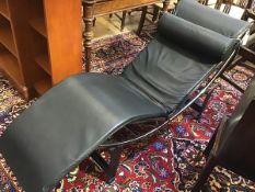 A modern Le Corbusier style recliner with anodised metal frame and black leather upholstery and neck