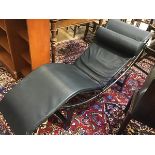 A modern Le Corbusier style recliner with anodised metal frame and black leather upholstery and neck