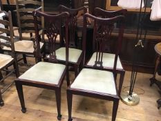 A set of four stained Edwardian pierced splat back dining chairs with slip in seats, on square