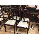 A set of four stained Edwardian pierced splat back dining chairs with slip in seats, on square