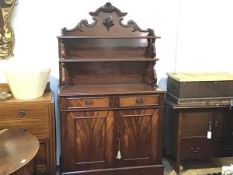 An early Victorian figured mahogany chiffonier, with relief carved scrolling crest over two