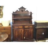 An early Victorian figured mahogany chiffonier, with relief carved scrolling crest over two