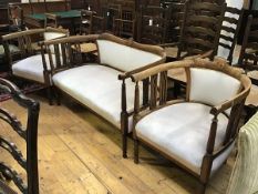 An Edwardian stained beech inlaid three piece drawing room suite comprising a two seater sofa with