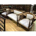 An Edwardian stained beech inlaid three piece drawing room suite comprising a two seater sofa with