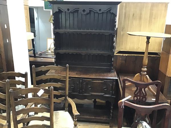 A 1920s oak dresser, the moulded cornice above two open shelves, above two frieze drawers, with