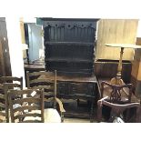 A 1920s oak dresser, the moulded cornice above two open shelves, above two frieze drawers, with