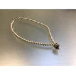 A cultured pearl necklace mounted with Indian enamelled octagonal seed pearl mounted pendant (22cm)