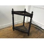 A 1930s oak carved corner stick stand with arcaded frieze raised on bobbin turned supports