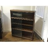 A modern three section mahogany upright sectional style bookcase fitted three pairs of sliding