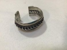 A Kenyan white metal cuff style two section adjustable bracelet with rope pattern cord centre panel,