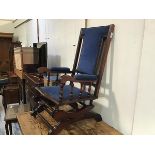 A 19thc walnut American style rocker chair with upholstered panel back, arms and seat, in blue