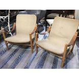 A pair of 1960s beech frame canvas back and seat chairs with leather strap armrests, on turned