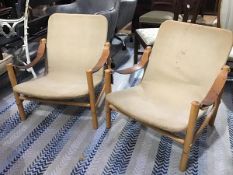 A pair of 1960s beech frame canvas back and seat chairs with leather strap armrests, on turned