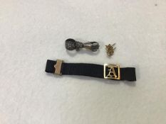 A Victorian silk cord bracelet mounted with engraved initial A, with clip fastening (2.51g), a white