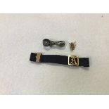 A Victorian silk cord bracelet mounted with engraved initial A, with clip fastening (2.51g), a white