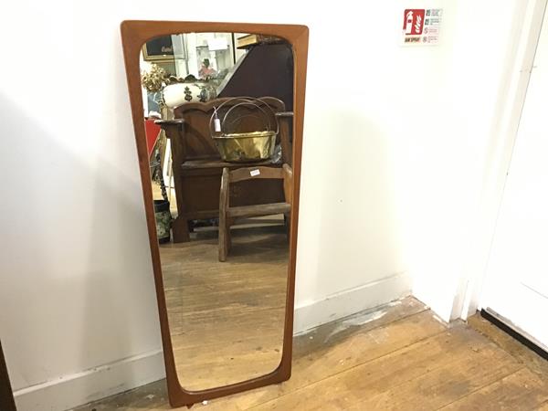 A 1970s teak shaped wall mirror (h.82cm. widest: 40cm)