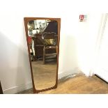 A 1970s teak shaped wall mirror (h.82cm. widest: 40cm)