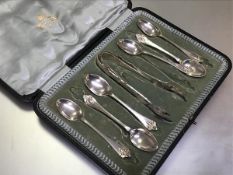 A set of six Edwardian Sheffield silver teaspoons with lily terminals with matching pair of tongs