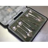 A set of six Edwardian Sheffield silver teaspoons with lily terminals with matching pair of tongs