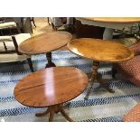 A pair and one yew wood oval pedestal occasional tables, raised on fluted bipod supports (the pair