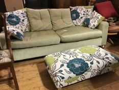 A modern three seater sofa upholstered in lime green plush fabric with squab and scatter floral