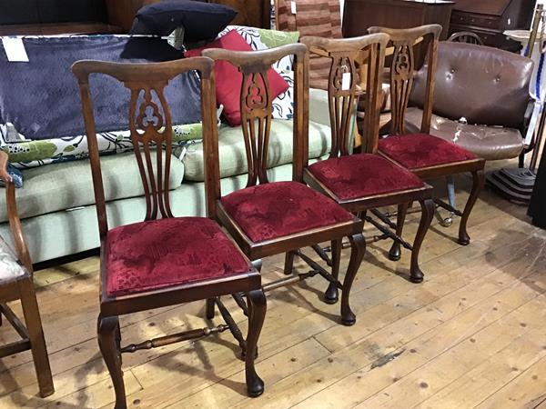 A set of four beech stained pierced splat back side chairs with slip in seats, on carved moulded
