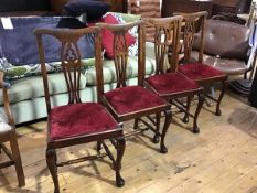 A set of four beech stained pierced splat back side chairs with slip in seats, on carved moulded