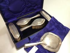 An Edwardian Birmingham silver five piece dressing table brush set comprising hand mirror, pair of