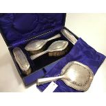 An Edwardian Birmingham silver five piece dressing table brush set comprising hand mirror, pair of