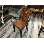 A 19thc mahogany shield back hall chair with shaped seat, raised on octagonal tapered and turned