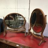 An Edwardian bleached mahogany oval swing mirror, raised on shaped end supports (h.49cm x 48cm), and