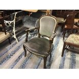 A beechwood reproduction fauteuil with arched carved panel upholstered back and upholstered arms and