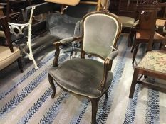 A beechwood reproduction fauteuil with arched carved panel upholstered back and upholstered arms and