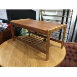 A teak coffee table, the rectangular top with moulded edge, on square supports, united by slatted