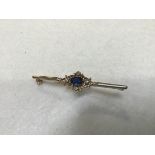 A 9ct gold bar brooch mounted centre blue oval stone, set surround of four diamonds (l.5cm. blue