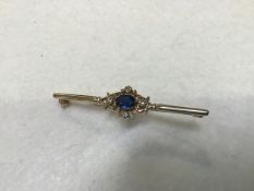 A 9ct gold bar brooch mounted centre blue oval stone, set surround of four diamonds (l.5cm. blue