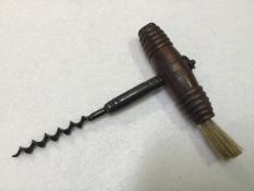 A treen barrel form corkscrew with bristle brush to side and loop to top (l.15cm)