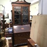 An Edwardian mahogany inlaid bureau bookcase, the broken swan neck pediment with dentil cornice