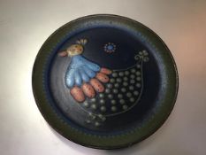 A Continental pottery plate decorated with stylised chicken design, c.1960 (d.28cm)