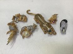 A collection of animal and bird paste set brooches including tiger, leopard, penguin, bear cub and