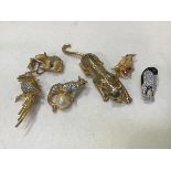 A collection of animal and bird paste set brooches including tiger, leopard, penguin, bear cub and