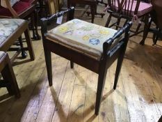 A stained beech box top piano stool with twin turned handles to side, enclosing miscellaneous