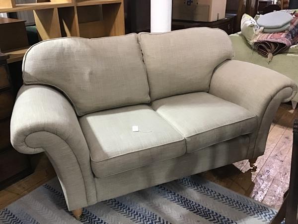 A modern two seater beechwood framed drawing room settee upholstered in oatmeal linen style