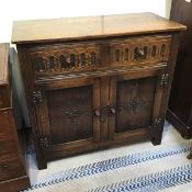 An oak side cabinet, the rectangular top with moulded edge above two frieze drawers and a pair of